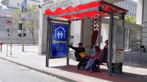 Unhoused people in bus shelter respond the the Cancel the Rents caravan in SF. Liberation photo.